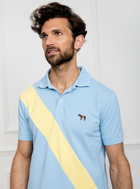 Man wearing sky blue 100% cotton polo shirt with lemon yellow sash detail and Newmarket 875 horse logo embroidered on the front.